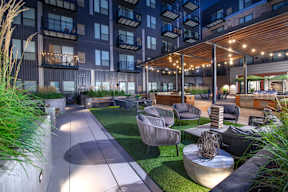 a rendering of a patio area with tables and chairs in an apartment building
