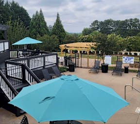 A blue umbrella is open on a patio.