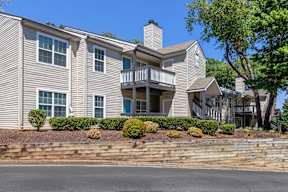 A two-story house with a balcony and a chimney.