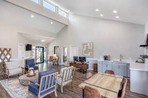 A modern living room with a large wooden table and blue chairs.