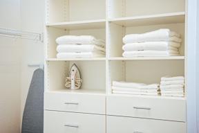 Organized closet shelving with white linens and iron at Reserve on 3rd Apartments, Alabama