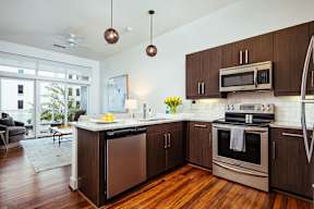 Kitchen island with granite countertop and pendant lighting at Reserve on 3rd Apartments, Birmingham, AL 35233