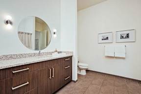 Spacious bathroom with dual vanity and framed artwork at Reserve on 3rd Apartments, Birmingham, AL