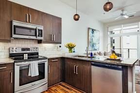 Kitchen with wood cabinetry and granite countertops at Reserve on 3rd Apartments, Birmingham, 35233