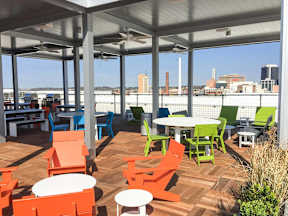 Rooftop patio with colorful outdoor furniture and city skyline at Reserve on 3rd Apartments, Alabama