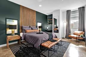 A modern bedroom with a large bed and a chair.