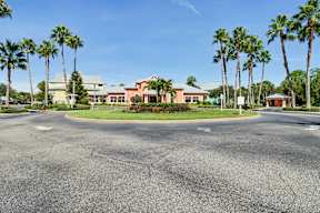 A roundabout with palm trees in front of a building.
