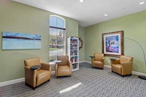 A room with a green wall and a painting of a beach scene on the wall.