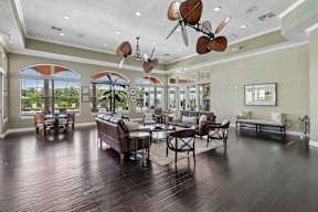 A spacious living room with a dark wood floor and a ceiling fan.