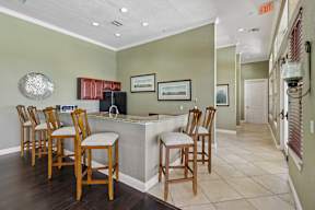 A kitchen with a bar and chairs.