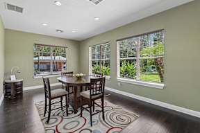 A dining room with a table and chairs.