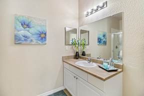 A bathroom with a sink and a mirror.