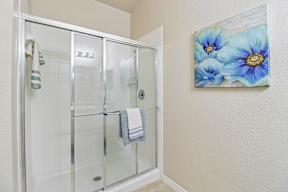 A shower with a glass door and a towel hanging on the rack.