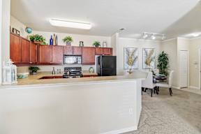 A kitchen with brown cabinets and a white counter.