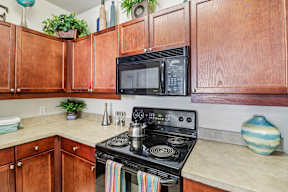 A kitchen with a black microwave above a stove.