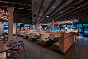 A restaurant with wooden furniture and a bar area.