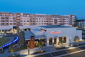 A building with a red sign that says "Casa Elredo" in front of a parking lot.
