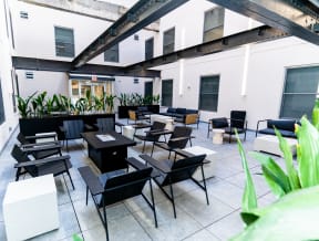 a large patio with tables and chairs in a room with white walls
