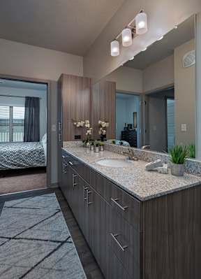 A modern bathroom with a large mirror and a sink.