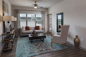 A living room with a sofa, a chair, a coffee table, and a rug.