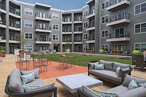 Apartment complex with a patio area in front.