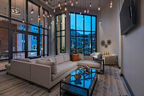 A modern living room with a large window and a flat screen TV mounted on the wall.