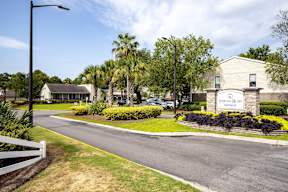 A street view of a Sterling Bluff community with a white fence on the left.