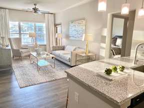 A well-lit, modern living room with a kitchen area.