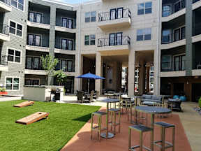 A patio area with a table and chairs is in front of a building.