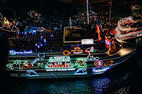 A boat with the words "Savages Slaggars" written on it is docked at night.