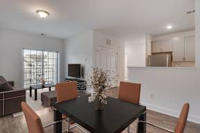 A dining room with a black table and orange chairs.