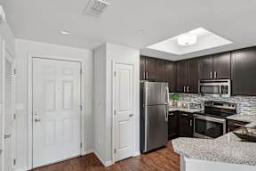A kitchen with a refrigerator, oven, and microwave.