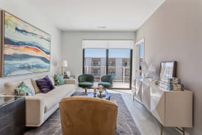 a living room with a couch and a chair and a window