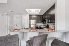 A modern kitchen with a dining table set for two.