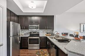 A kitchen with dark wood cabinets and stainless steel appliances.