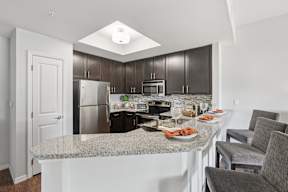 A kitchen with a granite countertop and a breakfast spread.