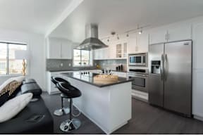 A modern kitchen with a black bench and a wooden island.