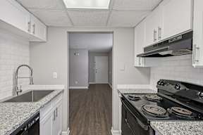 A kitchen with a stove top oven and a sink.