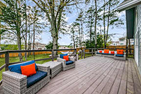 a large deck with furniture on it and trees