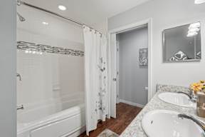 A white bathroom with a white tub and sink.