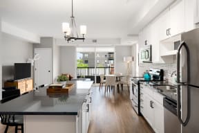 Vintage on Selby | St. Paul, MN |a kitchen and living room with white cabinets and stainless steel appliances