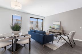 a living room with a blue couch and a table with chairs