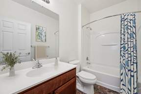 A white bathroom with a white toilet and a white sink.