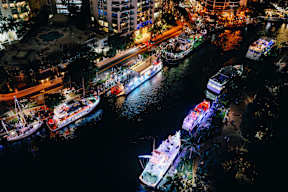 A nighttime view of a city with boats docked in the water.