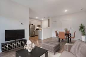 A modern living room with a black coffee table and a flat screen TV.