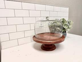 A glass dome is on top of a wooden base.