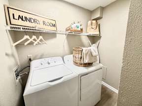 A small laundry room with a washer and dryer.