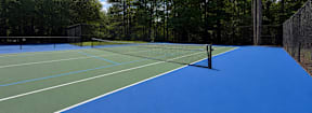 A tennis court with a blue surface and white lines.