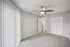 A room with a ceiling fan and a carpeted floor.