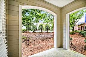 A view of a backyard through an arched doorway.